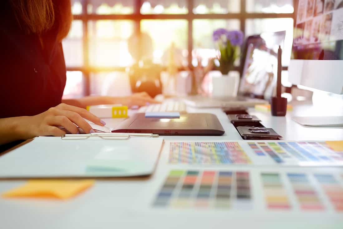 Arbeitsplatz einer Designerin mit Skizzen und Farbmustern